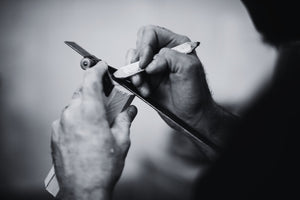 Black and white closeup photo of a man marking the center of a turning blank