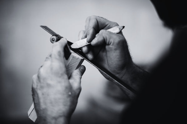 Black and white closeup photo of a man marking the center of a turning blank